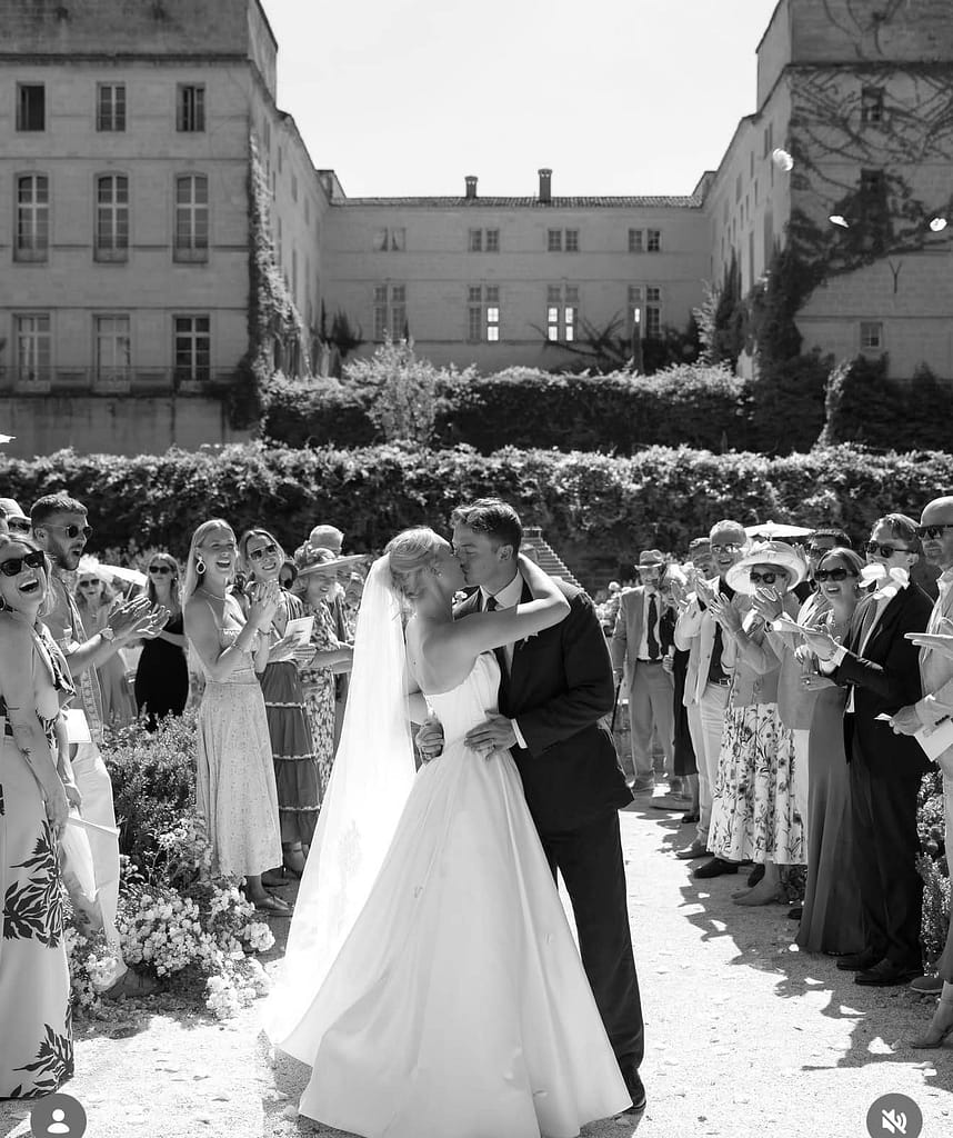 A black and white image of a bride and groom surrounded by clapping attendees. Situated outside. Image promotes Lexi's destination weddings bridal makeup.
Lexi Brownfield - Bridal & Wedding Makeup Artist Essex.