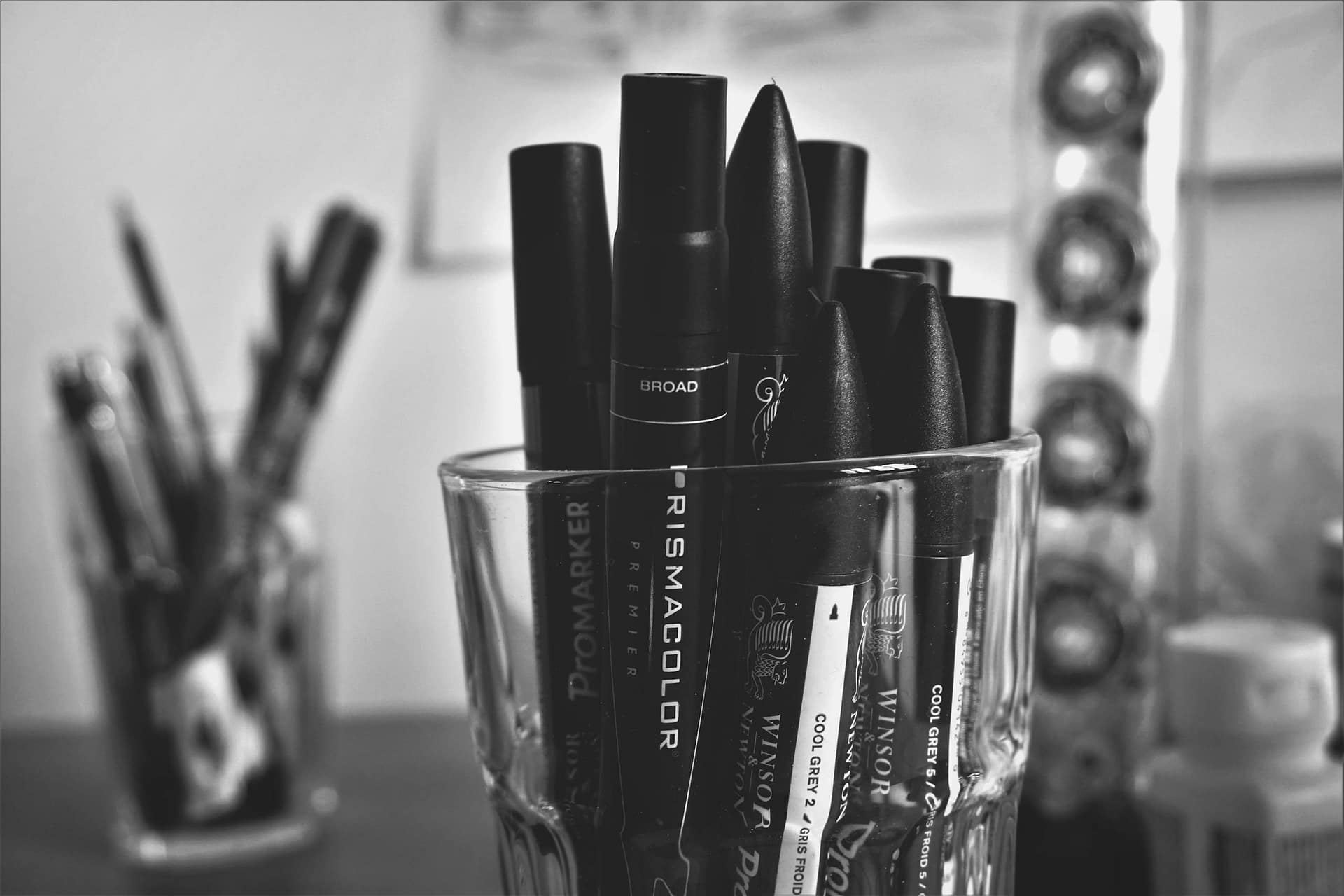 Close-up of black and white markers in a glass, perfect for artistic and business themes.